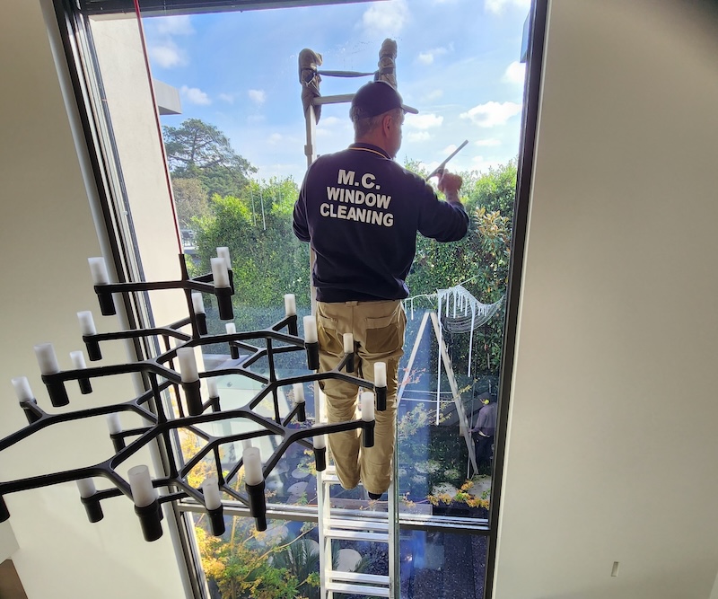 mc window cleaning, man on ladder cleaning residential windows